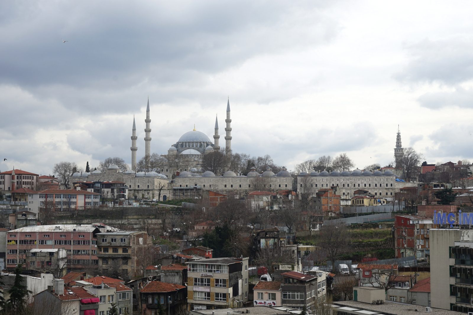 Süleymaniye Mosque on its hilltop above the rooftops of Fatih, its dome and four minarets grey against a heavy sky.
