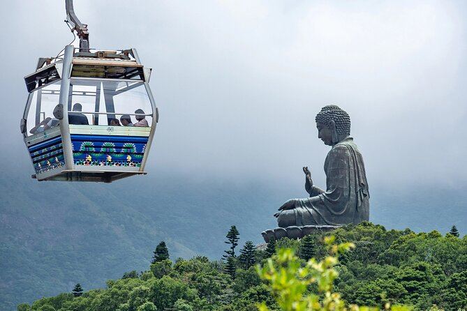A Ngong Ping 360 cable car cabin crossing the Lantau hills, with the Big Buddha beyond