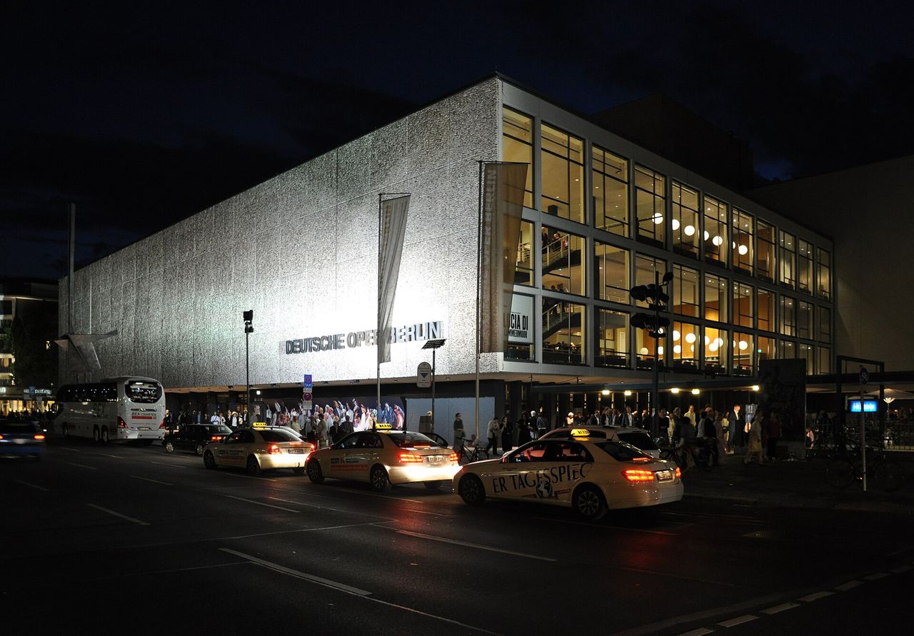 The lit facade of the Deutsche Oper Berlin on Bismarckstrasse at night