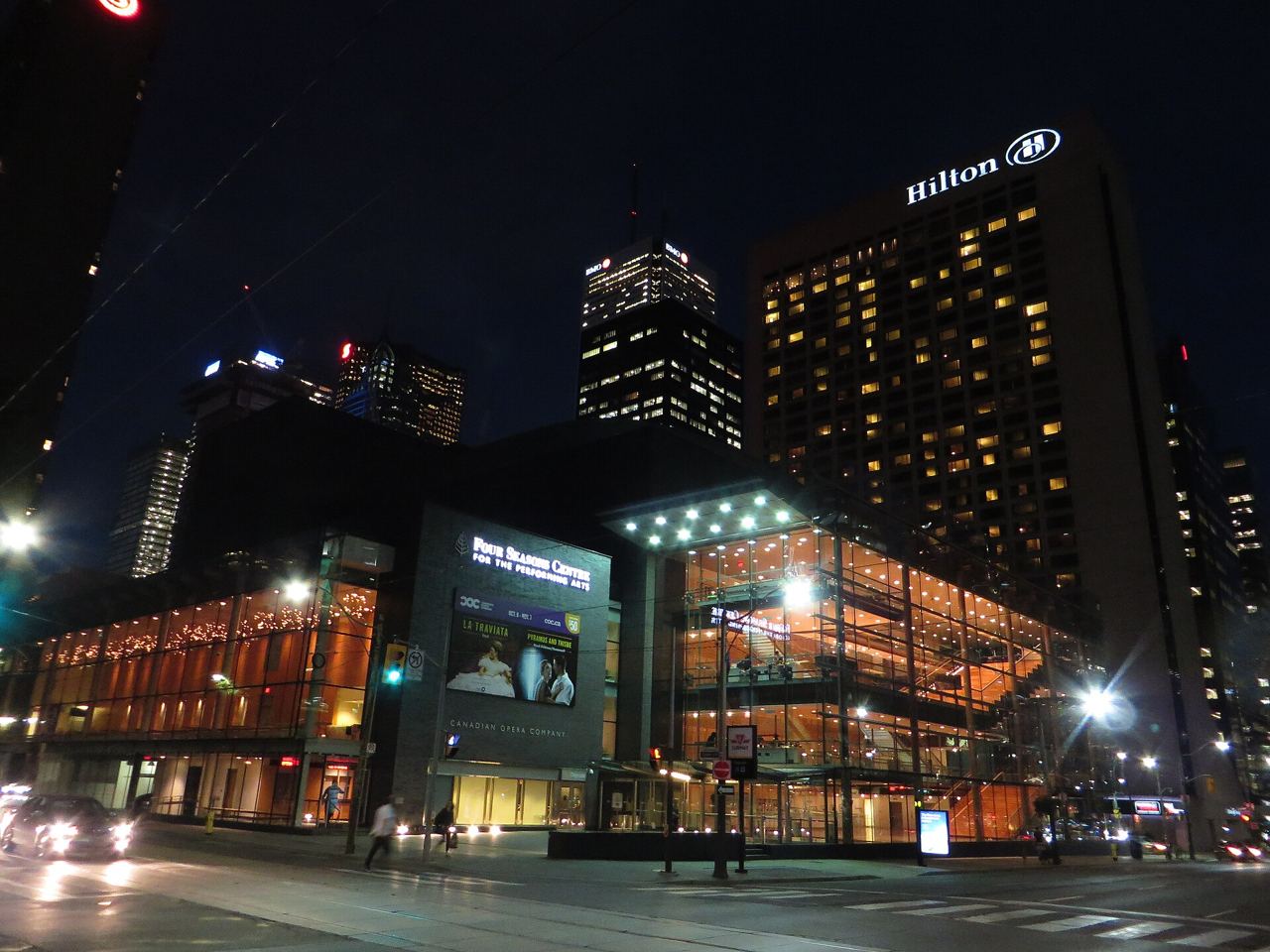 The lit glass lobby of the Four Seasons Centre for the Performing Arts in Toronto at night