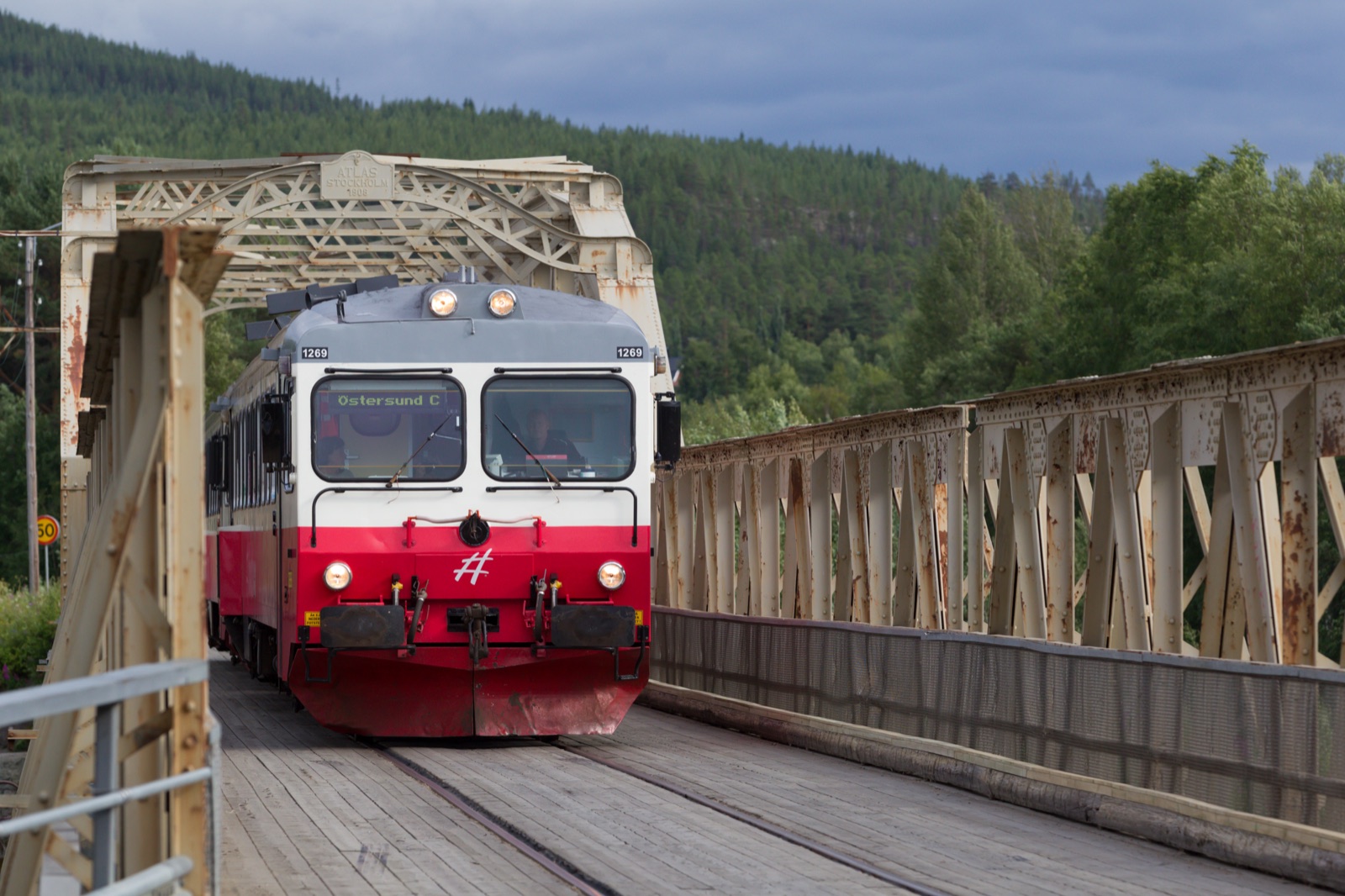An Inlandsbanan railcar crossing a timber bridge in the northern Swedish forest.